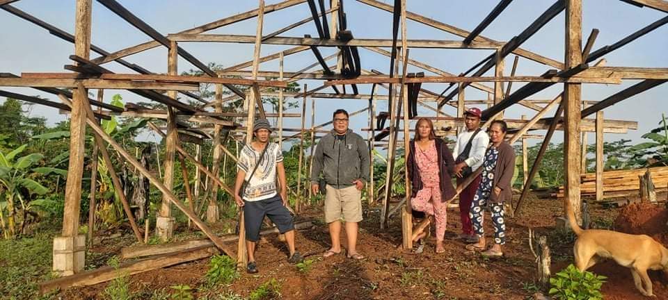 Community members assessing a damaged structure and planning rebuilding priorities in the Philippines
